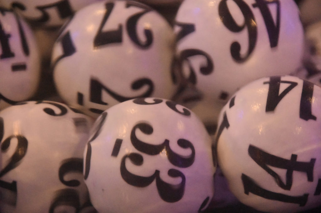 close up of white lottery balls with black numbers on them