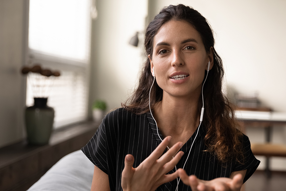 Video conversation. Inspired latin female teacher in headphones meet students online look at camera give virtual class. Portrait of confident young saleswoman wear headset consult client by videocall