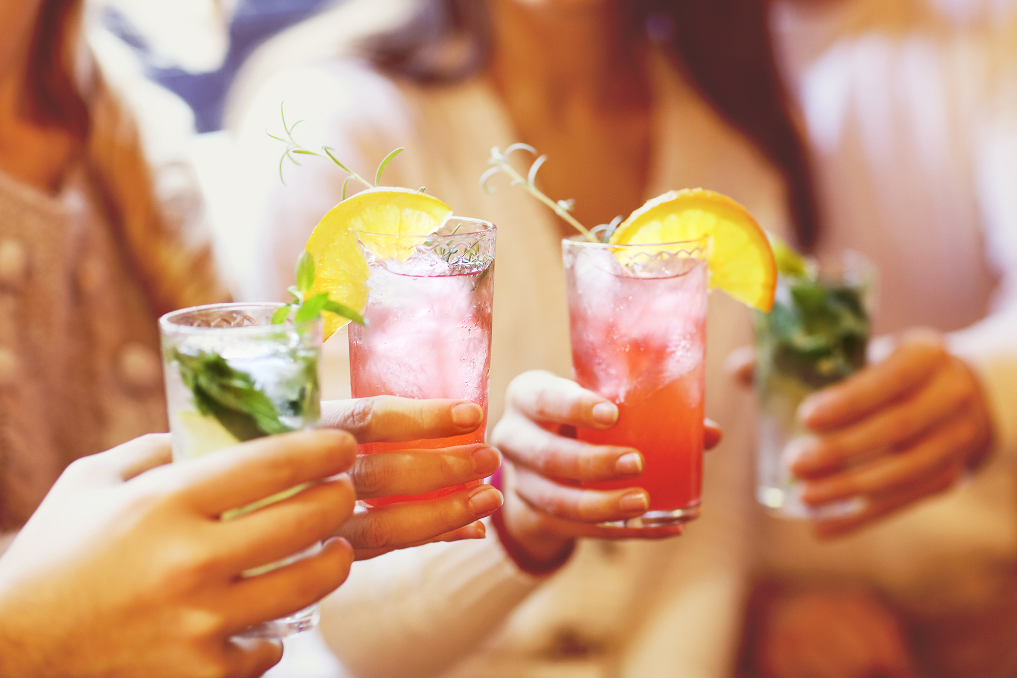 Young men and women drinking cocktail at party