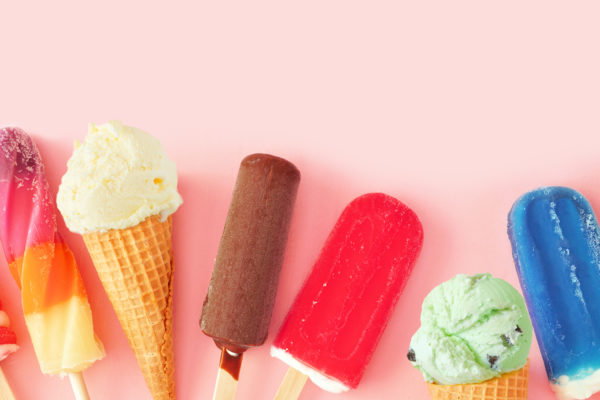 CollectiCollection of colorful summer frozen desserts. Top view bottom border on a pink background. Copy space.on of colorful summer frozen desserts, bottom border on a pink background