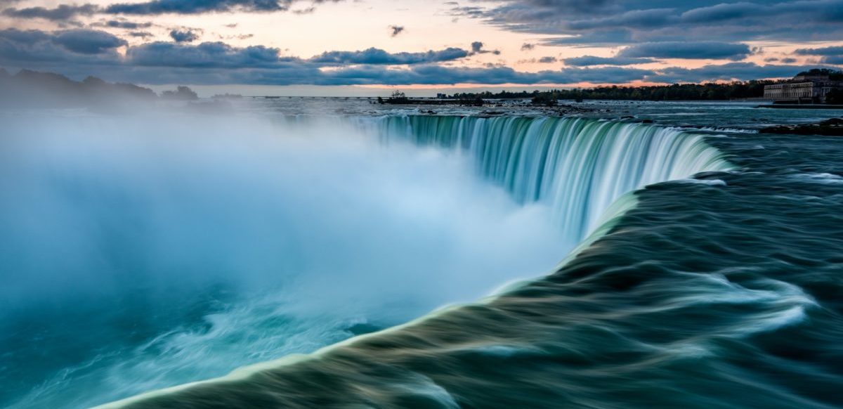 close up of river rushing at top of Niagara Falls with mist from below drifting upwards